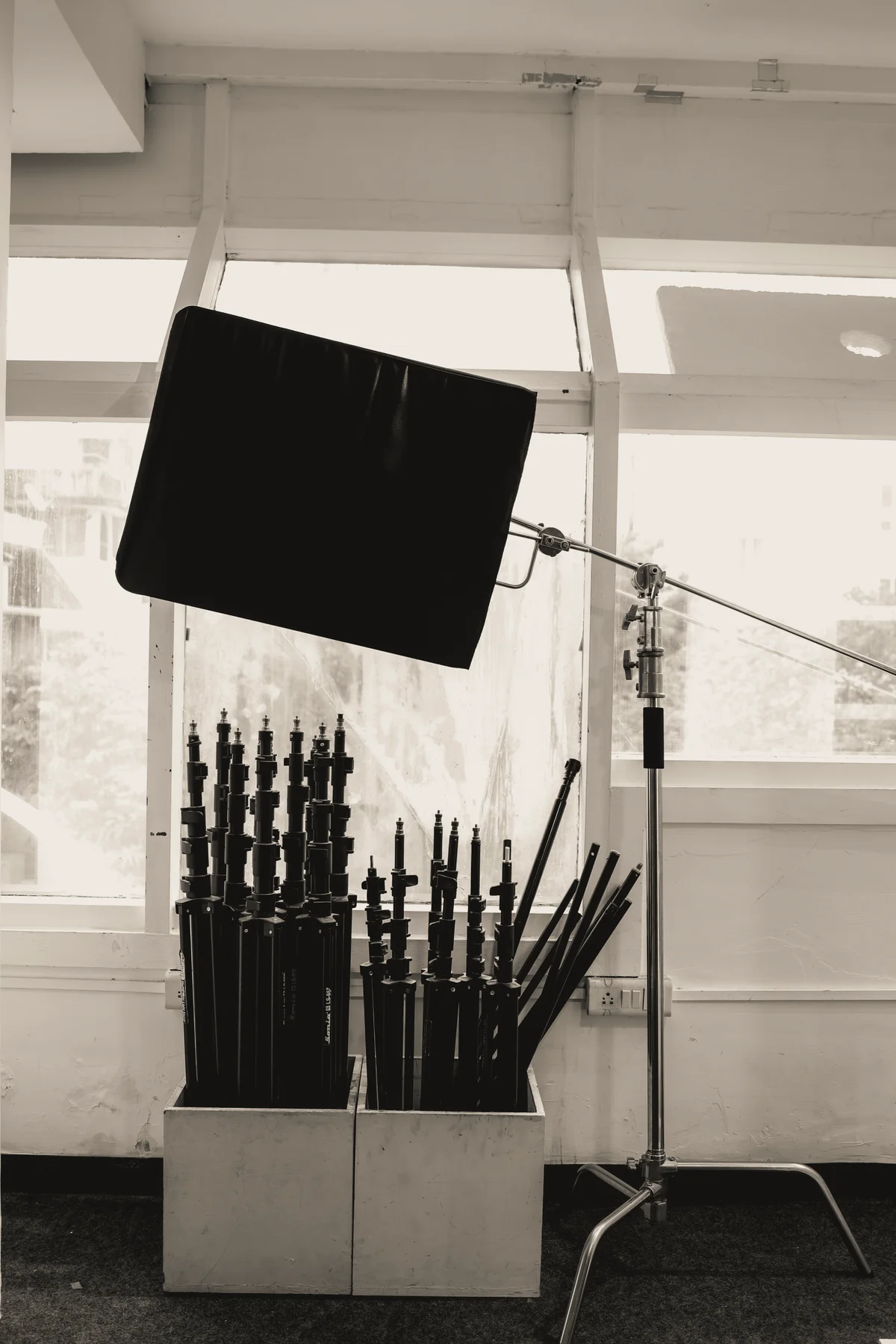 Studio windows with lighting modifiers and equipment beside the shoot floor