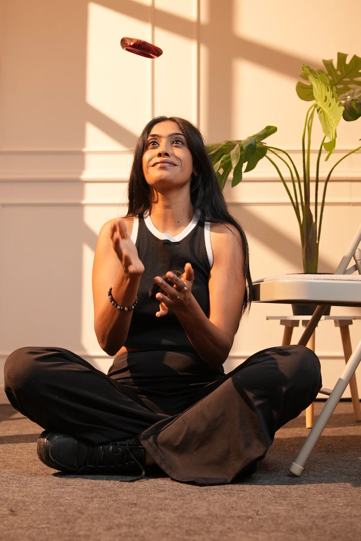 A full seated portrait with warm light and shadows.